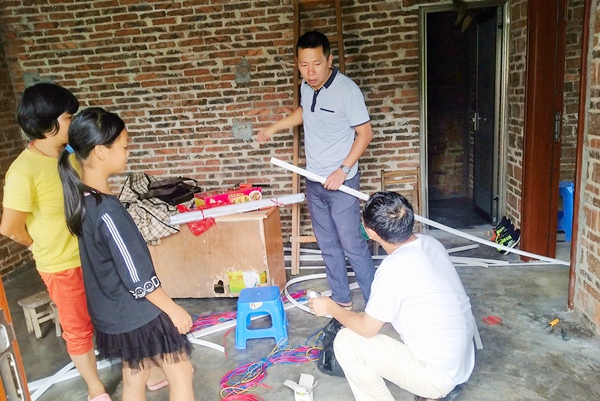 4图为梁洪波帮助贫困户施扬源安装室内电路.jpg
