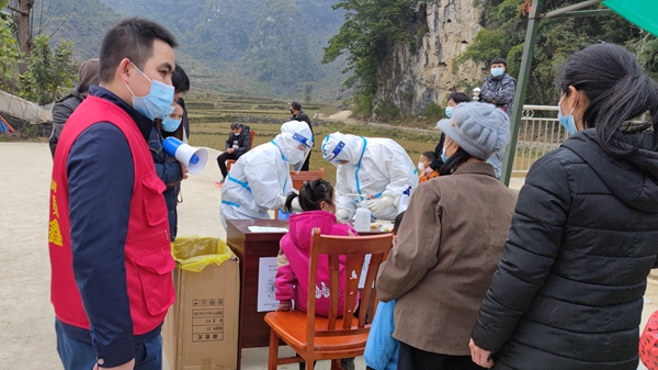 图为农工党员韦鑫在引导村民进行核酸检测.jpg